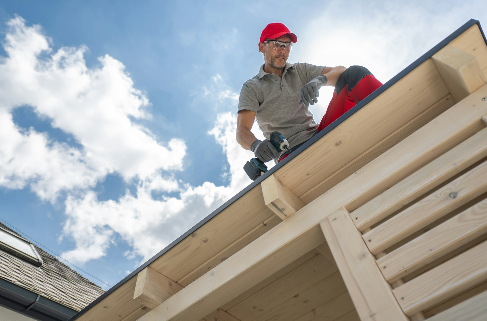 Construction Worker on Roof Using Drill